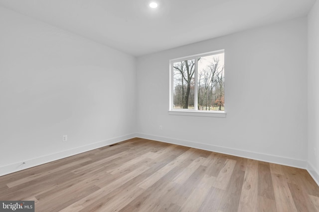 unfurnished room featuring recessed lighting, light wood-type flooring, baseboards, and visible vents