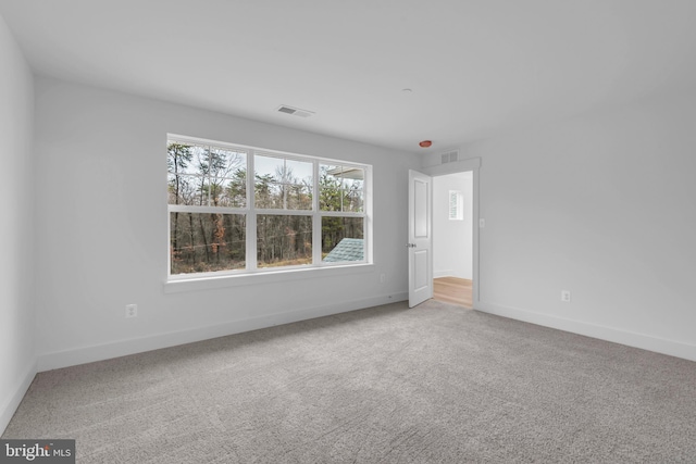 unfurnished room featuring visible vents, baseboards, and carpet flooring