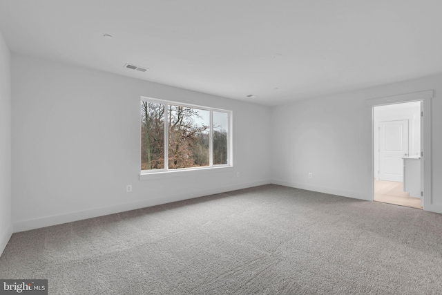 unfurnished room featuring visible vents, baseboards, and carpet floors