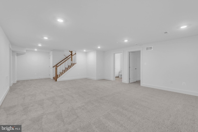 finished basement with recessed lighting, visible vents, light colored carpet, and stairs