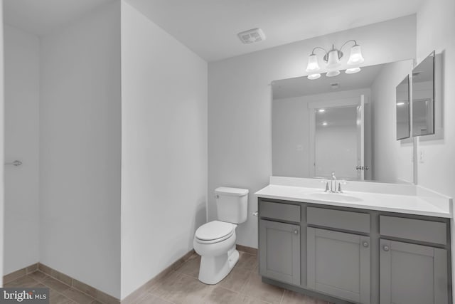 bathroom featuring tile patterned flooring, toilet, vanity, and baseboards