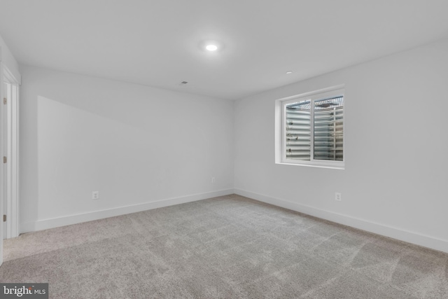 empty room featuring carpet flooring, recessed lighting, and baseboards