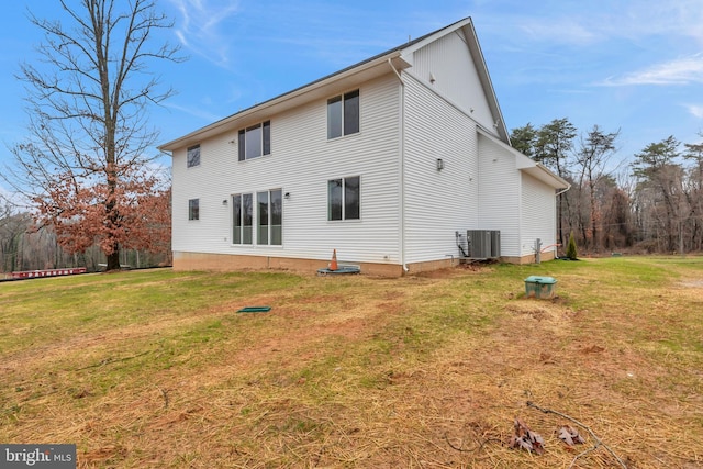 rear view of house featuring central AC and a yard