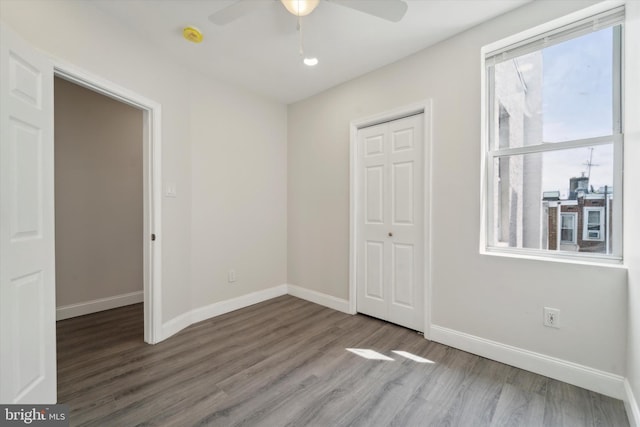 unfurnished bedroom with a closet, ceiling fan, and wood-type flooring