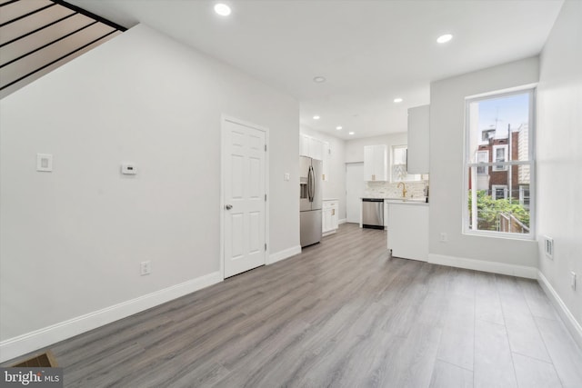 interior space with a healthy amount of sunlight, sink, and light hardwood / wood-style floors