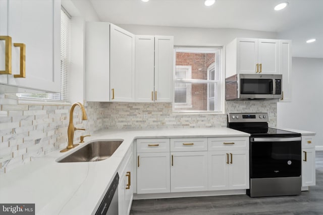 kitchen featuring dark hardwood / wood-style floors, backsplash, appliances with stainless steel finishes, sink, and white cabinets