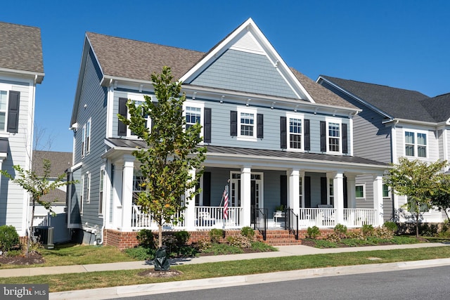 view of front of property with central air condition unit, a standing seam roof, a porch, roof with shingles, and metal roof