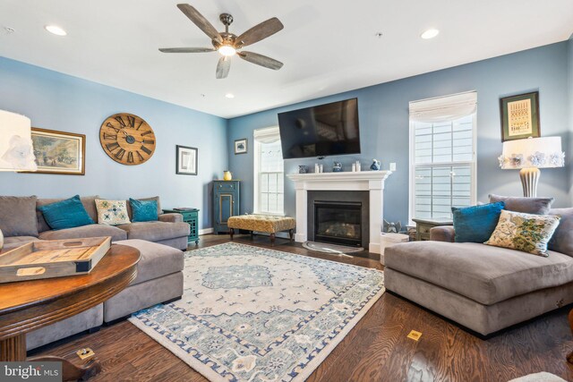 living area featuring a fireplace with flush hearth, wood finished floors, recessed lighting, and ceiling fan