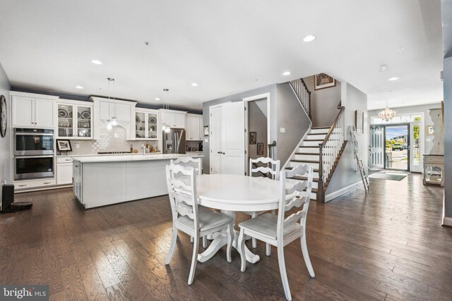 dining area featuring dark wood finished floors, stairway, recessed lighting, and a chandelier