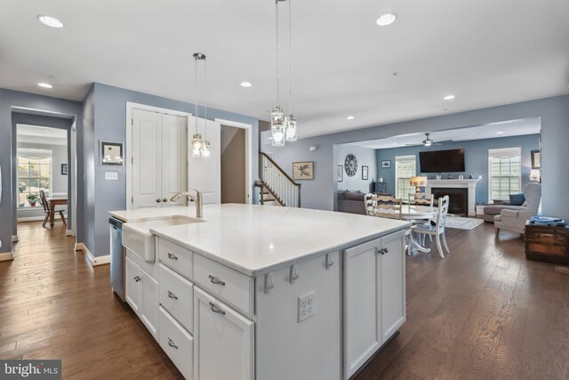 kitchen featuring dishwasher, dark wood-type flooring, recessed lighting, and a fireplace