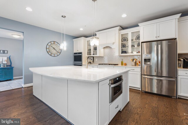 kitchen with tasteful backsplash, appliances with stainless steel finishes, dark wood-style floors, and white cabinetry