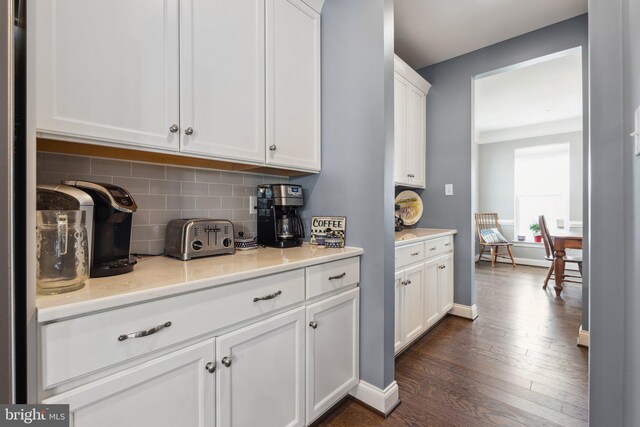 bar featuring dark wood-style floors, tasteful backsplash, and baseboards