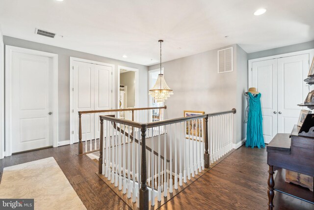 corridor featuring visible vents, an upstairs landing, dark wood-style floors, recessed lighting, and baseboards