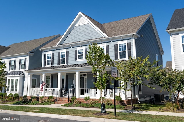 view of front of home with a porch, roof with shingles, central AC unit, metal roof, and a standing seam roof