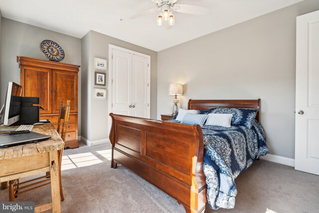 bedroom with a ceiling fan, light colored carpet, baseboards, and a closet