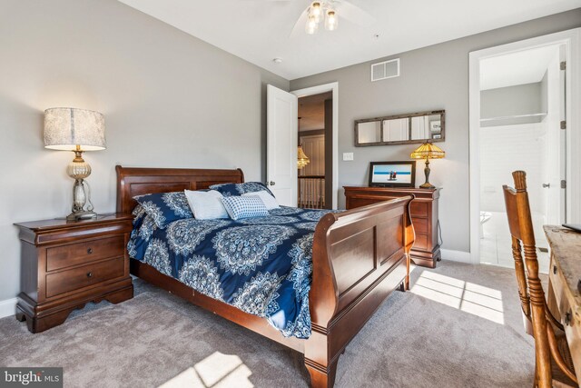 carpeted bedroom featuring visible vents, ensuite bath, and baseboards