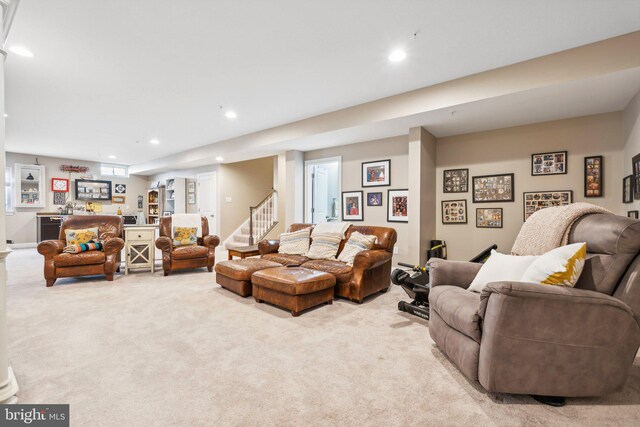 living area with a bar, recessed lighting, light colored carpet, and stairs