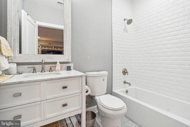 bathroom with vanity, bathing tub / shower combination, toilet, and baseboards