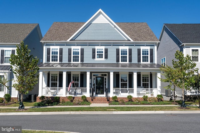 view of front of property with a porch, a shingled roof, and a standing seam roof