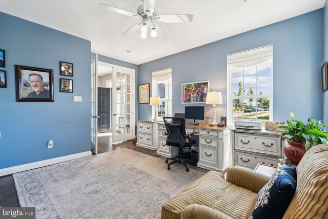 home office featuring wood finished floors, french doors, baseboards, and ceiling fan