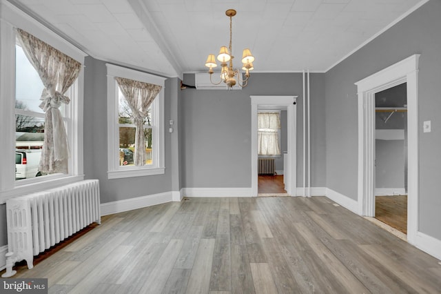 unfurnished dining area featuring an inviting chandelier, crown molding, radiator, and light hardwood / wood-style flooring