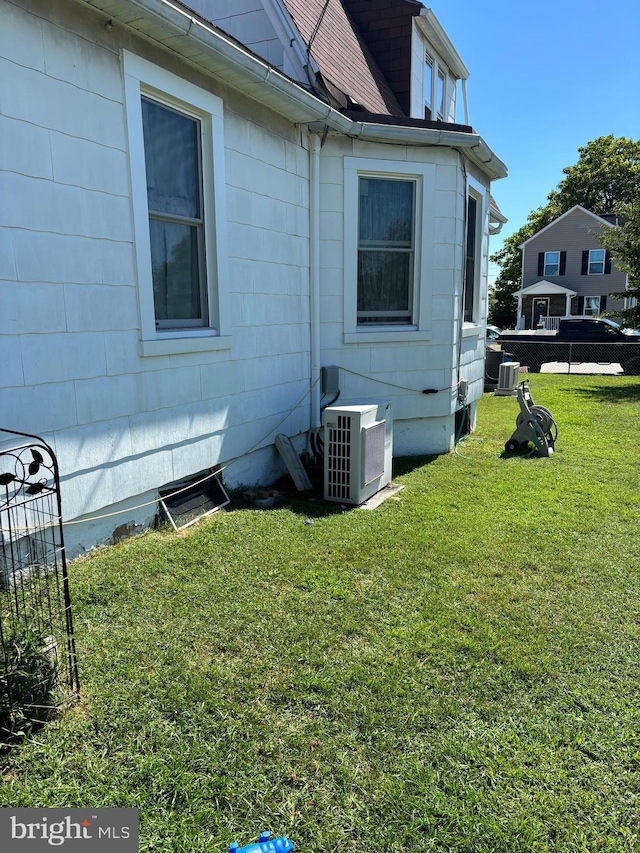 view of property exterior with ac unit and a yard