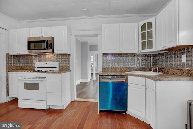 kitchen with light wood-type flooring, white cabinetry, ornamental molding, and appliances with stainless steel finishes