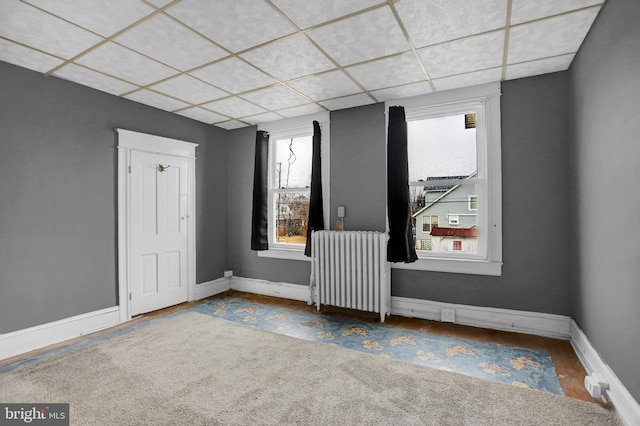 spare room with a paneled ceiling and radiator heating unit