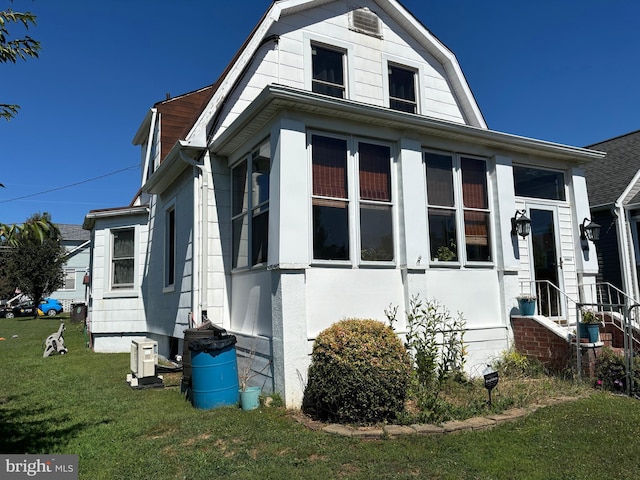 view of side of property with a sunroom and a yard