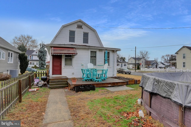 bungalow-style home with central AC unit and a wooden deck