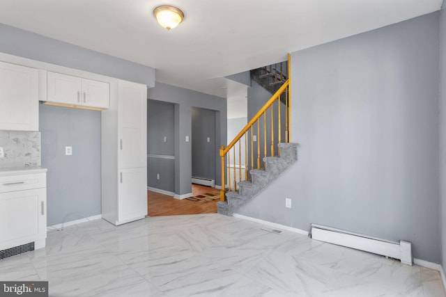 interior space featuring a baseboard heating unit, stairway, baseboards, and marble finish floor