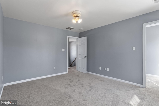 empty room with visible vents, baseboards, and carpet