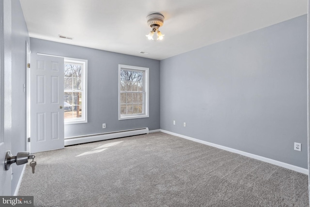 unfurnished room featuring a baseboard heating unit, baseboards, carpet, and visible vents