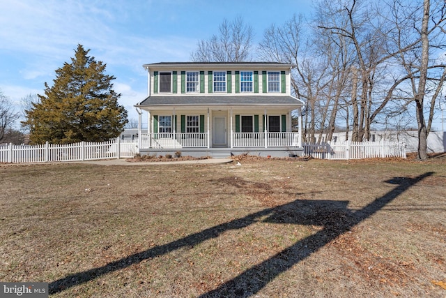 colonial inspired home with a porch, fence, and a front yard