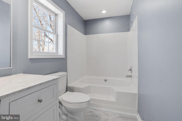 full bathroom with marble finish floor, toilet, vanity, and  shower combination