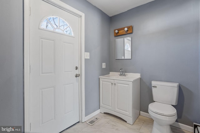 bathroom with visible vents, baseboards, toilet, marble finish floor, and vanity