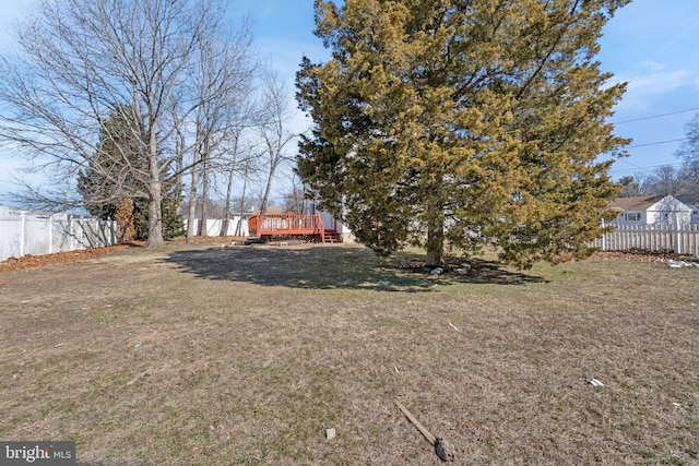 view of yard with a deck and fence