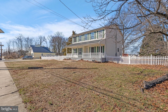 view of front of property with a porch, fence, and a front lawn