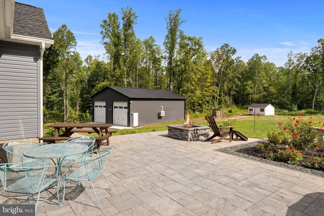 view of patio featuring a fire pit and a shed