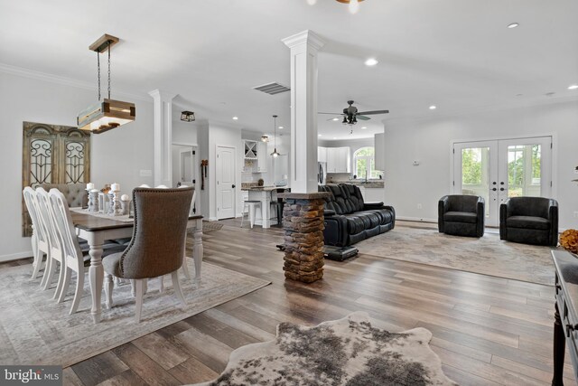 dining space featuring french doors, hardwood / wood-style flooring, and decorative columns