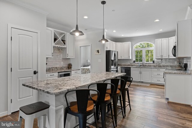 kitchen with black appliances, a center island, white cabinetry, and dark hardwood / wood-style flooring