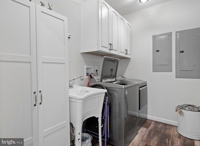 clothes washing area with cabinets, washing machine and dryer, electric panel, and dark hardwood / wood-style flooring