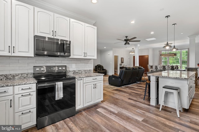 kitchen featuring stainless steel appliances, white cabinets, and ceiling fan