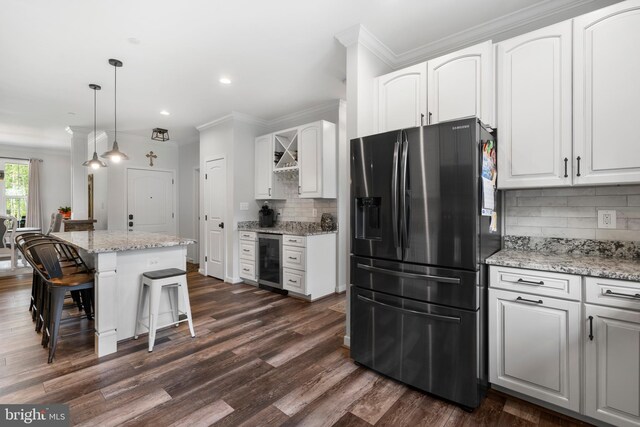 kitchen featuring a center island, stainless steel fridge, dark hardwood / wood-style floors, and white cabinetry