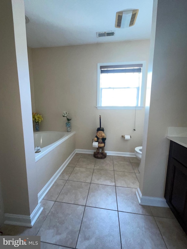 bathroom with tile patterned flooring, toilet, a bathing tub, and vanity