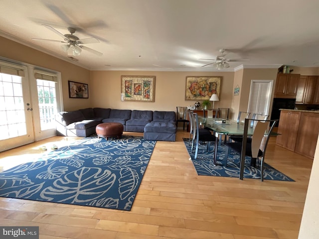 living room featuring crown molding, wood-type flooring, and ceiling fan