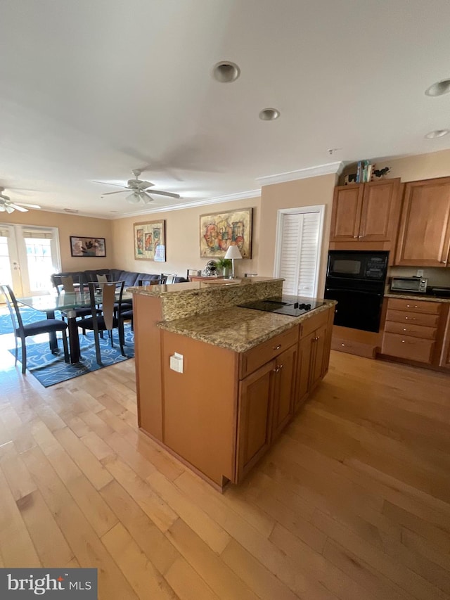 kitchen with light wood-type flooring, black appliances, crown molding, and ceiling fan