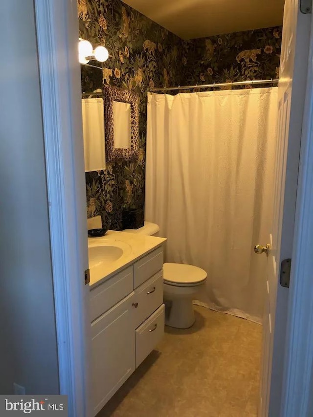 bathroom featuring curtained shower, toilet, and vanity