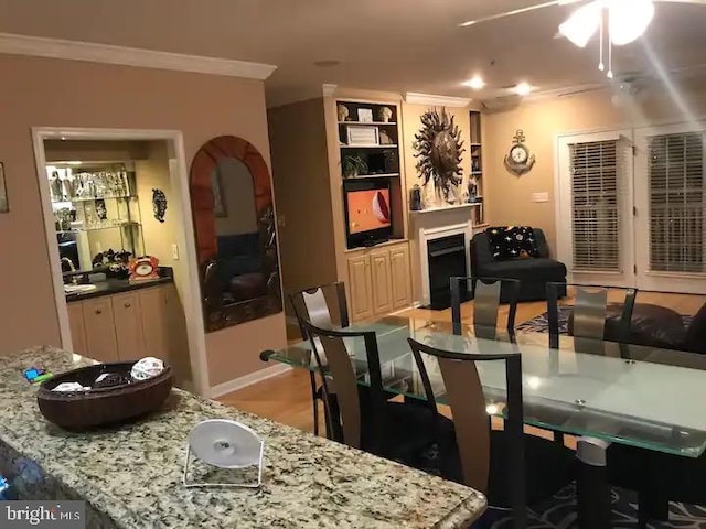 dining area with crown molding and ceiling fan