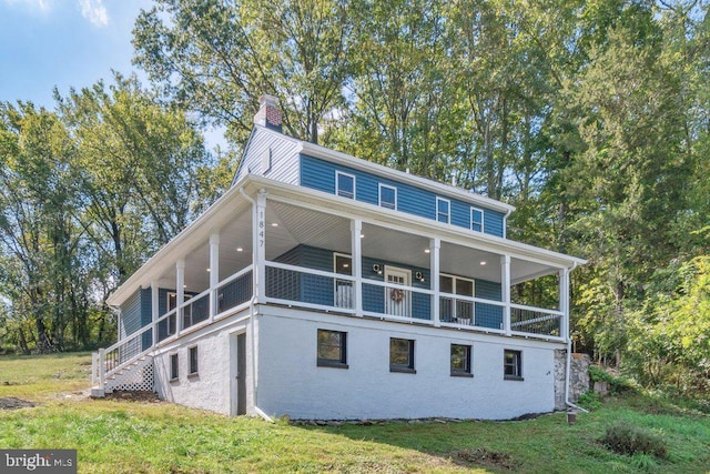 view of front of property featuring a balcony and a front yard